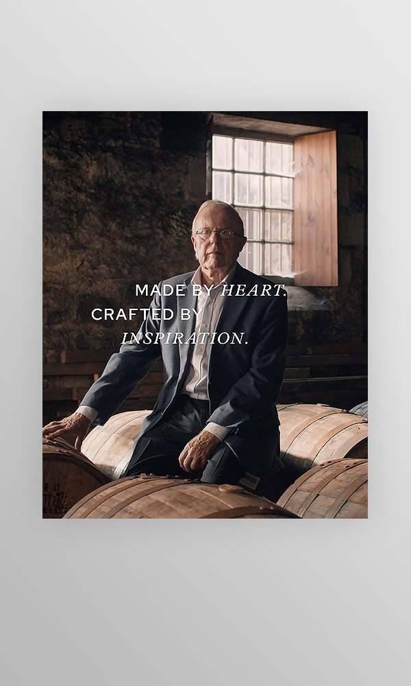 Ausschnitt aus Reel, Mann zwischen Whiskyfässern, Schrift: made by heart, crafted by inspiration