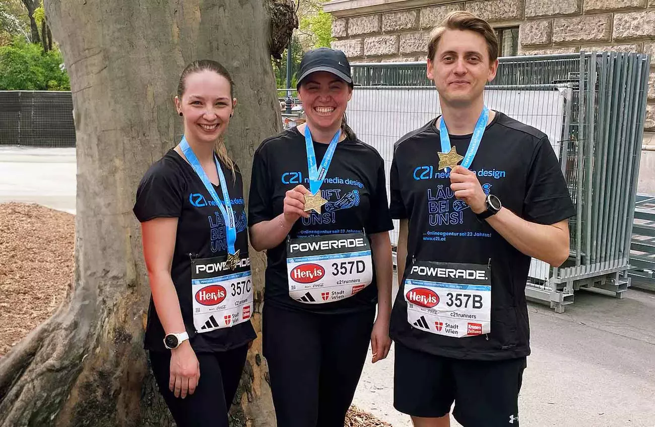 Karina, Andrea und Andriy zeigen ihre Medaillen nach dem Staffellauf beim Wien Marathon