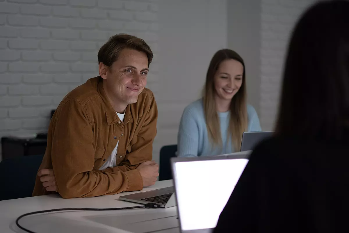 Andriy sitzend neben Karina im Besprechungsraum