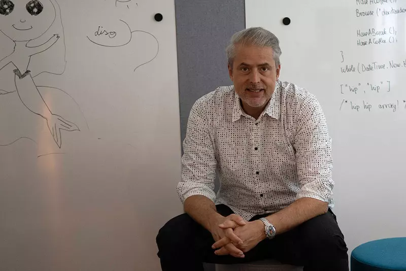Christoph (sitzend) vor Whiteboard Wand