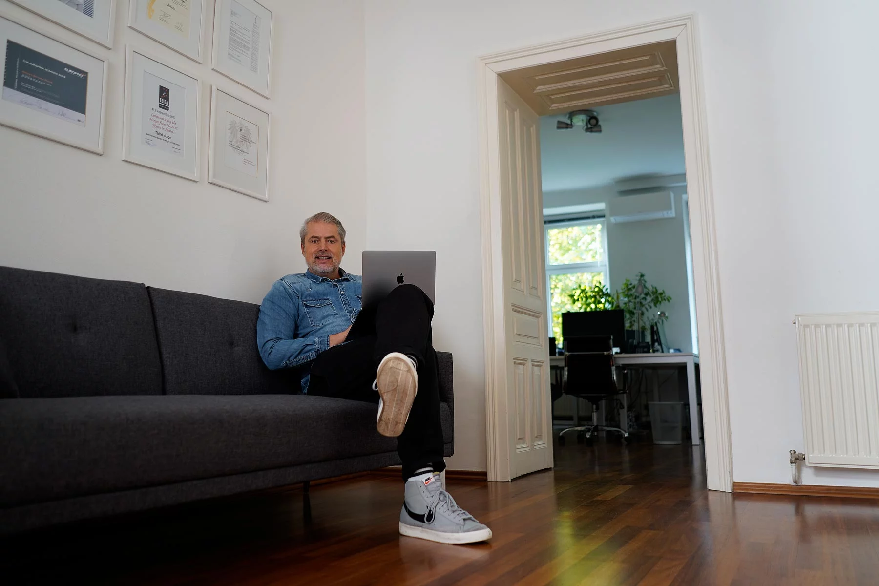 Christoph sitzt auf der Couch im Büro